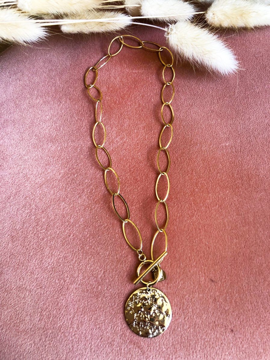 TIA, notre joli collier doré avec médaille à effet martelé. Il apportera une touche de lumière et de style à votre look ! Longueur collier : 40 cm Modèle en acier inoxydable Résiste à l’eau, ne noircit pas