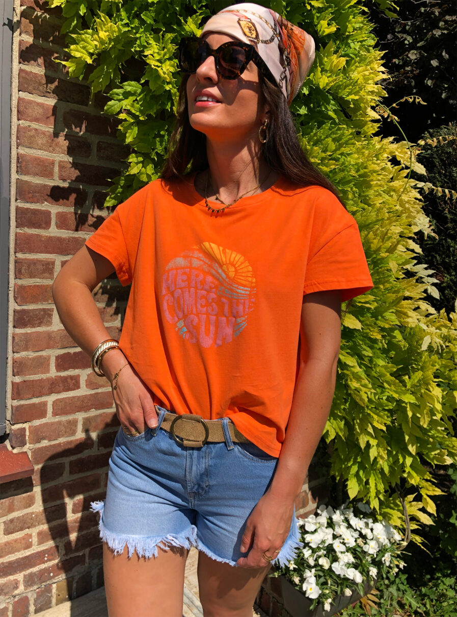 Notre tee-shirt à message “Here comes the sun” permettra d’apporter une touche de fun à vos looks ! Encolure ronde et manches courtes On aime son coloris orange pop qui donne bonne mine et qui se marie à merveille avec du jean ou du blanc. On aime le porter avec : Absolument tout ! Une jupe, un pantalon, un short, ce joli tee-shirt match avec tout.
