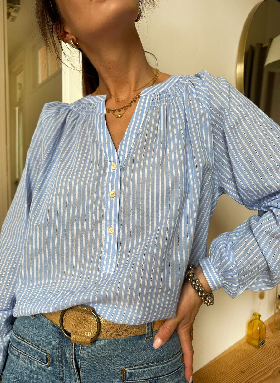 Lilou est une blouse bleue toute mignonne avec une fine rayure blanche façon jour échelle. Confectionnée en coton elle est très agréable à porter ! Col mao avec joli décolleté V Détails smocks au niveau du col 3 boutons sur l’avant Manches longues qui se ferment à l’aide d’un bouton