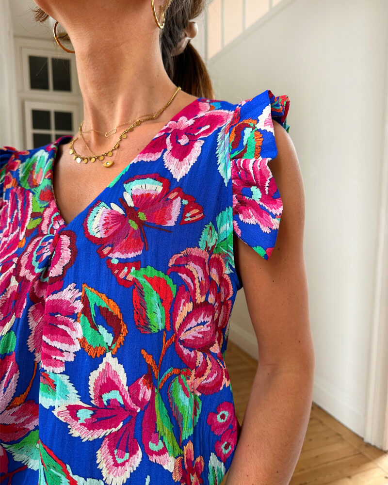 Voyez la vie en couleurs cet été ! Le top Isia sera votre parfait allié pour un look chic, bohême et estival ! Motif fleuri rose et bleu roi Joli décolleté en V et volants sur les épaules Fabrication française