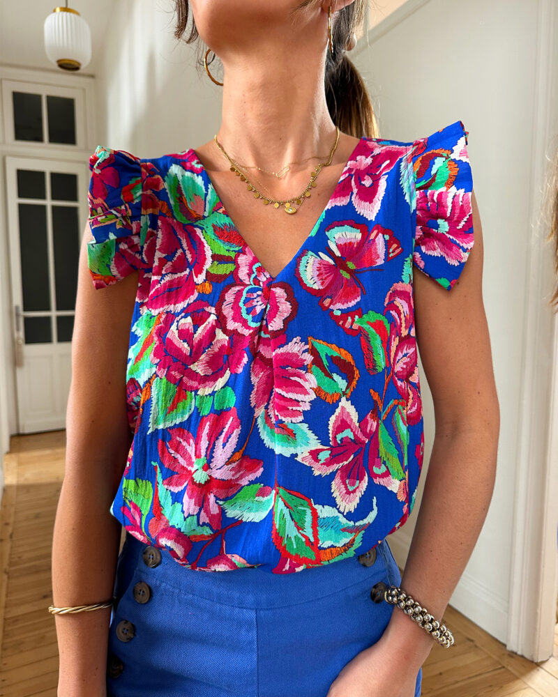 Voyez la vie en couleurs cet été ! Le top Isia sera votre parfait allié pour un look chic, bohême et estival ! Motif fleuri rose et bleu roi Joli décolleté en V et volants sur les épaules Fabrication française