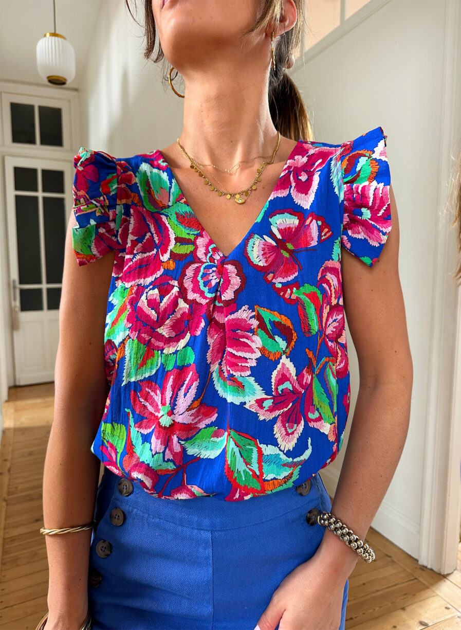 Voyez la vie en couleurs cet été ! Le top Isia sera votre parfait allié pour un look chic, bohême et estival ! Motif fleuri rose et bleu roi Joli décolleté en V et volants sur les épaules Fabrication française