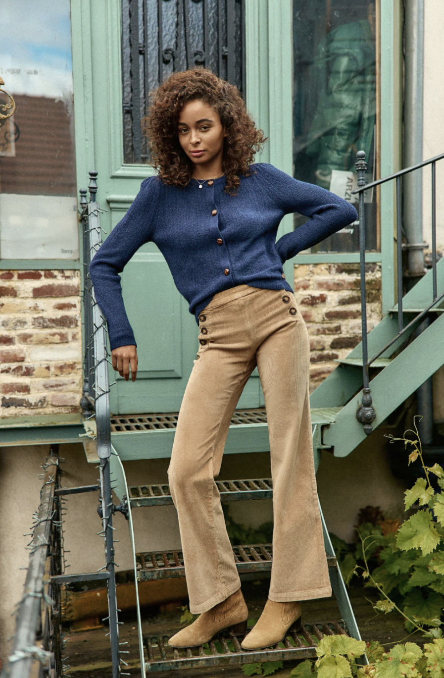 Voici notre nouveau pantalon PAO, édition velours ultra chic. Vos jambes s’allongent, c’est magique ! – Pantalon à ponts taille haute – Coupe flare qui allonge la jambe – Velours côtelé beige – Double patte de boutonnage – Fausses poches passepoilées à l’arrière – La mannequin mesure 173 cm et porte une taille 36 On aime le porter avec : un gros pull et une paire de bottines un look tendance automnal !