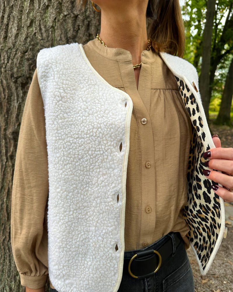 Affrontez l’hiver avec élégance et chaleur grâce à notre gilet SACHA sans manches. Une pièce incontournable pour un style chic et confortable par temps froid. Coupe droite Encolure en V Ouverture boutonnée devant Finitions gansées Veste effet peau de mouton ecru Doublure imprimé leopard