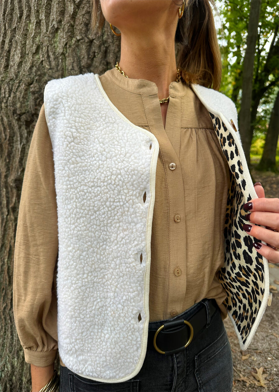 Affrontez l’hiver avec élégance et chaleur grâce à notre gilet SACHA sans manches. Une pièce incontournable pour un style chic et confortable par temps froid. Coupe droite Encolure en V Ouverture boutonnée devant Finitions gansées Veste effet peau de mouton ecru Doublure imprimé leopard