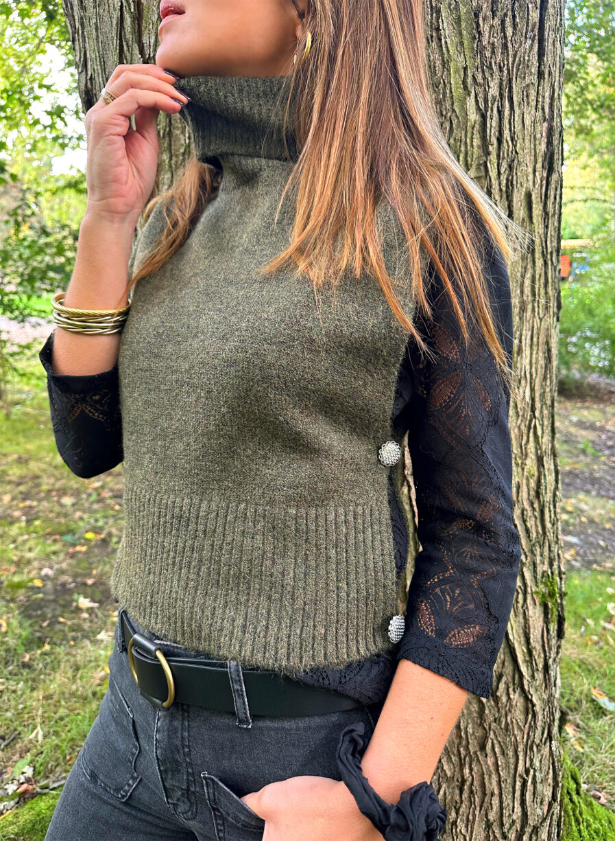 Craquez pour le Pull LIZA kaki sans manches en maille toute douce. Le nouveau best seller de votre garde robe pour cet hiver ! Col roulé Fabriqué en maille douce et stretch Boutons bijoux sur les côtés On aime le porter avec une jolie blouse ample par dessous, un pantalon noir ou beige assez chic et de jolies baskets pour casser le look !