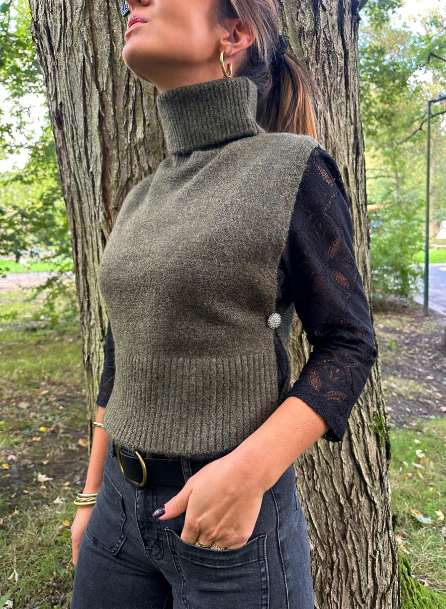 Craquez pour le Pull LIZA kaki sans manches en maille toute douce. Le nouveau best seller de votre garde robe pour cet hiver ! Col roulé Fabriqué en maille douce et stretch Boutons bijoux sur les côtés On aime le porter avec une jolie blouse ample par dessous, un pantalon noir ou beige assez chic et de jolies baskets pour casser le look !