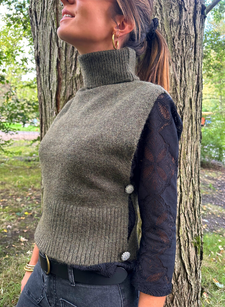 Craquez pour le Pull LIZA kaki sans manches en maille toute douce. Le nouveau best seller de votre garde robe pour cet hiver ! Col roulé Fabriqué en maille douce et stretch Boutons bijoux sur les côtés On aime le porter avec une jolie blouse ample par dessous, un pantalon noir ou beige assez chic et de jolies baskets pour casser le look !