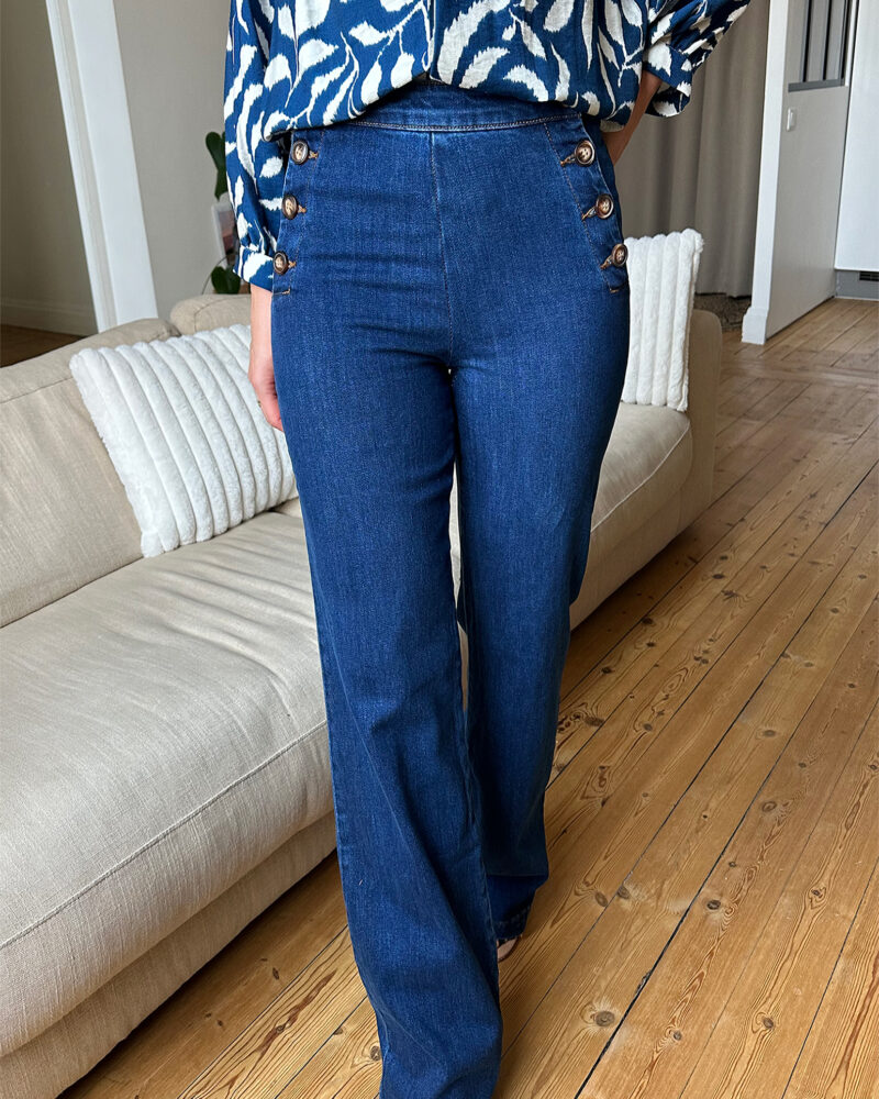 Voici MATT notre nouveau jean ultra tendance ! Modèle à ponts taille haute. Vos jambes s’allongent, c’est magique ! – Toile en coton – Boutons sur les côtés façon corne – Fausses poches passepoilées à l’arrière Il est tendance, confortable, durable et idéal pour un usage quotidien ! On adore l’associer à une grosse maille ou une jolie blouse bohème ! Ajoutez-y de jolis bijoux et un beau sac en cuir !