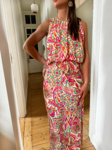 Voici JOLIA ! Notre nouvelle robe longue ultra canon, idéale pour vos occasions. Robe droite avec joli drapé à la taille qui lui apporte du charme. Robe longueur midi avec joli imprimé fuchsia, orange et vert Encolure ronde avec petites fronces Coupe droite Taille cintrée avec zip côté Modèle fendu sur le bas de la jambe, son atout charme Se ferme au dos à l’aide d’un petit bouton Fabrication Française On adore ajouter des touches de doré à cette robe ! Des sandales dorées, des bijoux dorés …