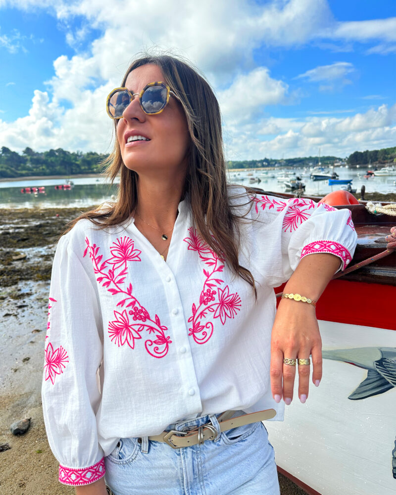La blouse ANNA représente l’élégance et la féminité grâce à ses somptueux détails en broderie fuchsia. Ses détails apporteront une touche de romantisme à vos looks. Idéale à porter avec un jean ou un short taille haute. Col mao avec joli décolleté V Modèle boutonné sur l’avant Détail de broderies fuchsias sur l’avant et sur les manches Manches 3/4 qui se ferment à l’aide d’un bouton