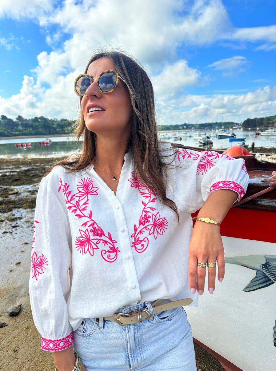 La blouse ANNA représente l’élégance et la féminité grâce à ses somptueux détails en broderie fuchsia. Ses détails apporteront une touche de romantisme à vos looks. Idéale à porter avec un jean ou un short taille haute. Col mao avec joli décolleté V Modèle boutonné sur l’avant Détail de broderies fuchsias sur l’avant et sur les manches Manches 3/4 qui se ferment à l’aide d’un bouton