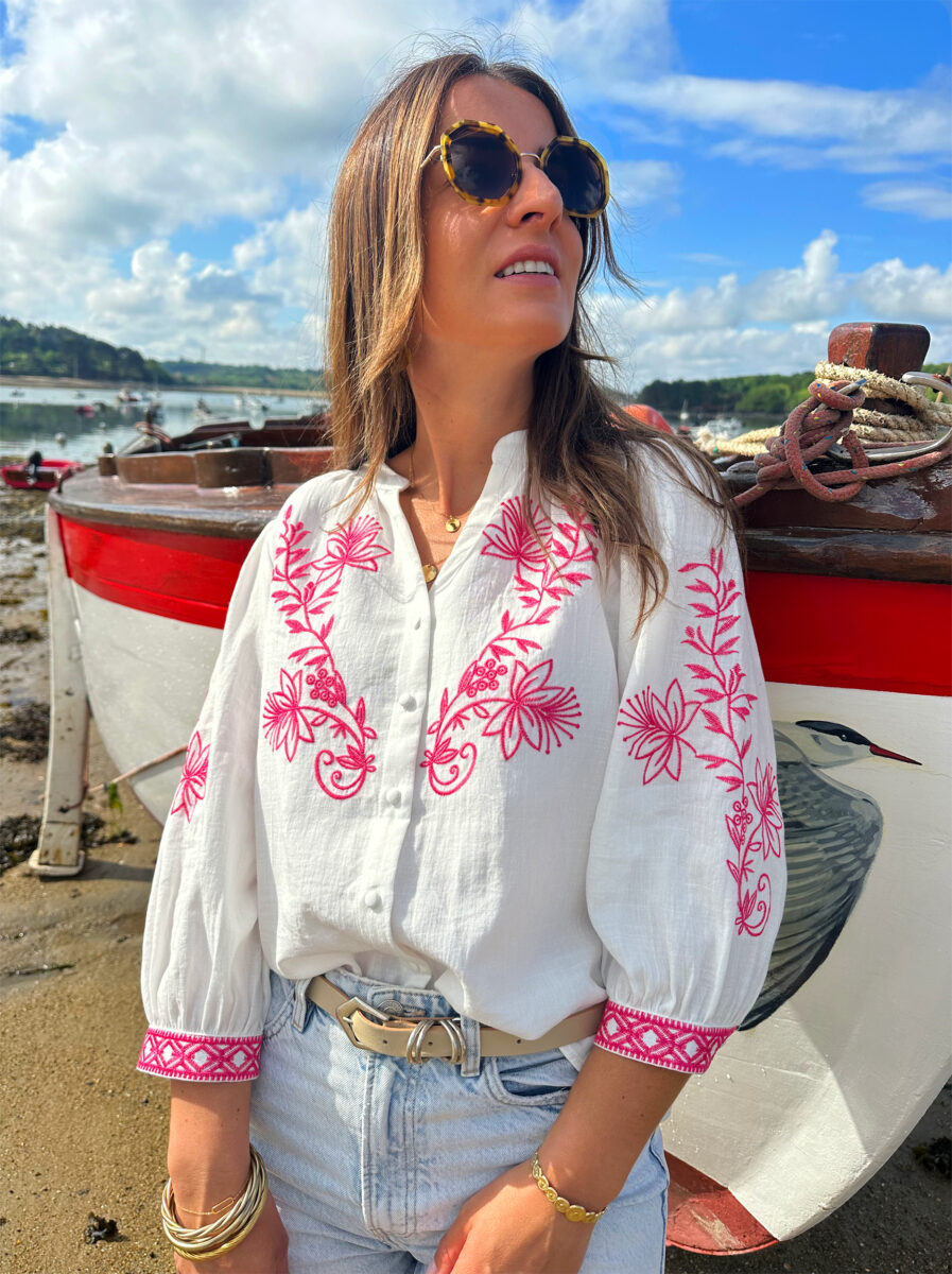 La blouse ANNA représente l’élégance et la féminité grâce à ses somptueux détails en broderie fuchsia. Ses détails apporteront une touche de romantisme à vos looks. Idéale à porter avec un jean ou un short taille haute. Col mao avec joli décolleté V Modèle boutonné sur l’avant Détail de broderies fuchsias sur l’avant et sur les manches Manches 3/4 qui se ferment à l’aide d’un bouton