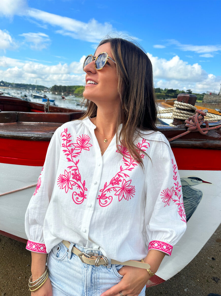 La blouse ANNA représente l’élégance et la féminité grâce à ses somptueux détails en broderie fuchsia. Ses détails apporteront une touche de romantisme à vos looks. Idéale à porter avec un jean ou un short taille haute. Col mao avec joli décolleté V Modèle boutonné sur l’avant Détail de broderies fuchsias sur l’avant et sur les manches Manches 3/4 qui se ferment à l’aide d’un bouton