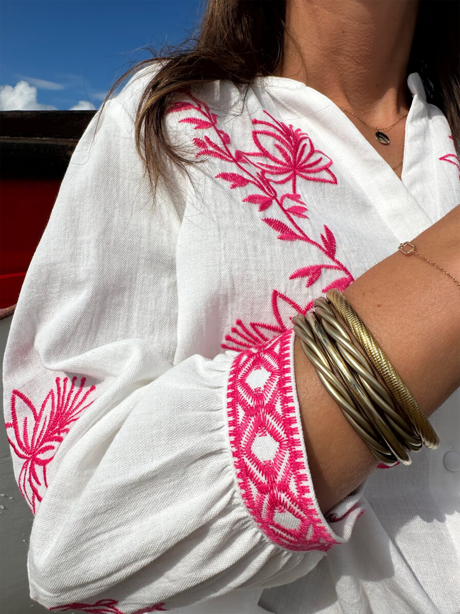 La blouse ANNA représente l’élégance et la féminité grâce à ses somptueux détails en broderie fuchsia. Ses détails apporteront une touche de romantisme à vos looks. Idéale à porter avec un jean ou un short taille haute. Col mao avec joli décolleté V Modèle boutonné sur l’avant Détail de broderies fuchsias sur l’avant et sur les manches Manches 3/4 qui se ferment à l’aide d’un bouton