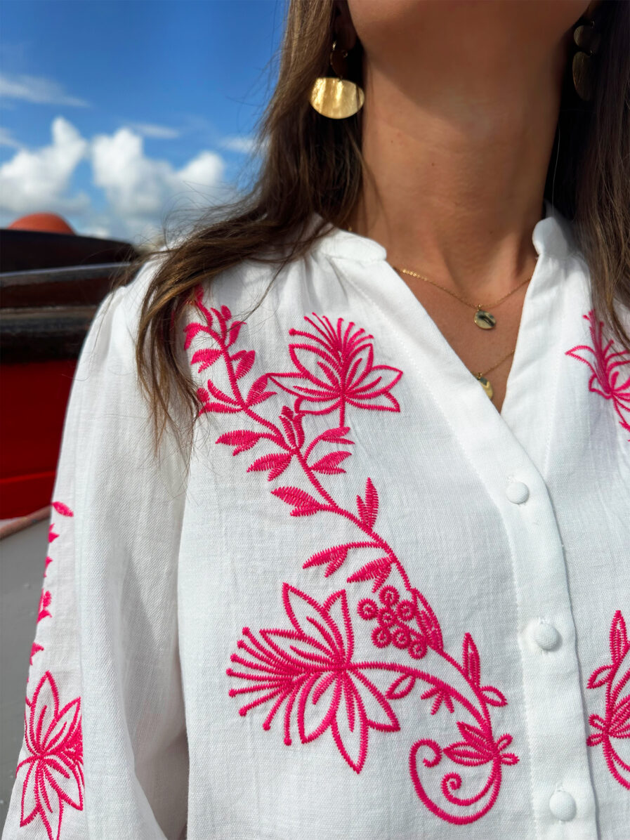 La blouse ANNA représente l’élégance et la féminité grâce à ses somptueux détails en broderie fuchsia. Ses détails apporteront une touche de romantisme à vos looks. Idéale à porter avec un jean ou un short taille haute. Col mao avec joli décolleté V Modèle boutonné sur l’avant Détail de broderies fuchsias sur l’avant et sur les manches Manches 3/4 qui se ferment à l’aide d’un bouton