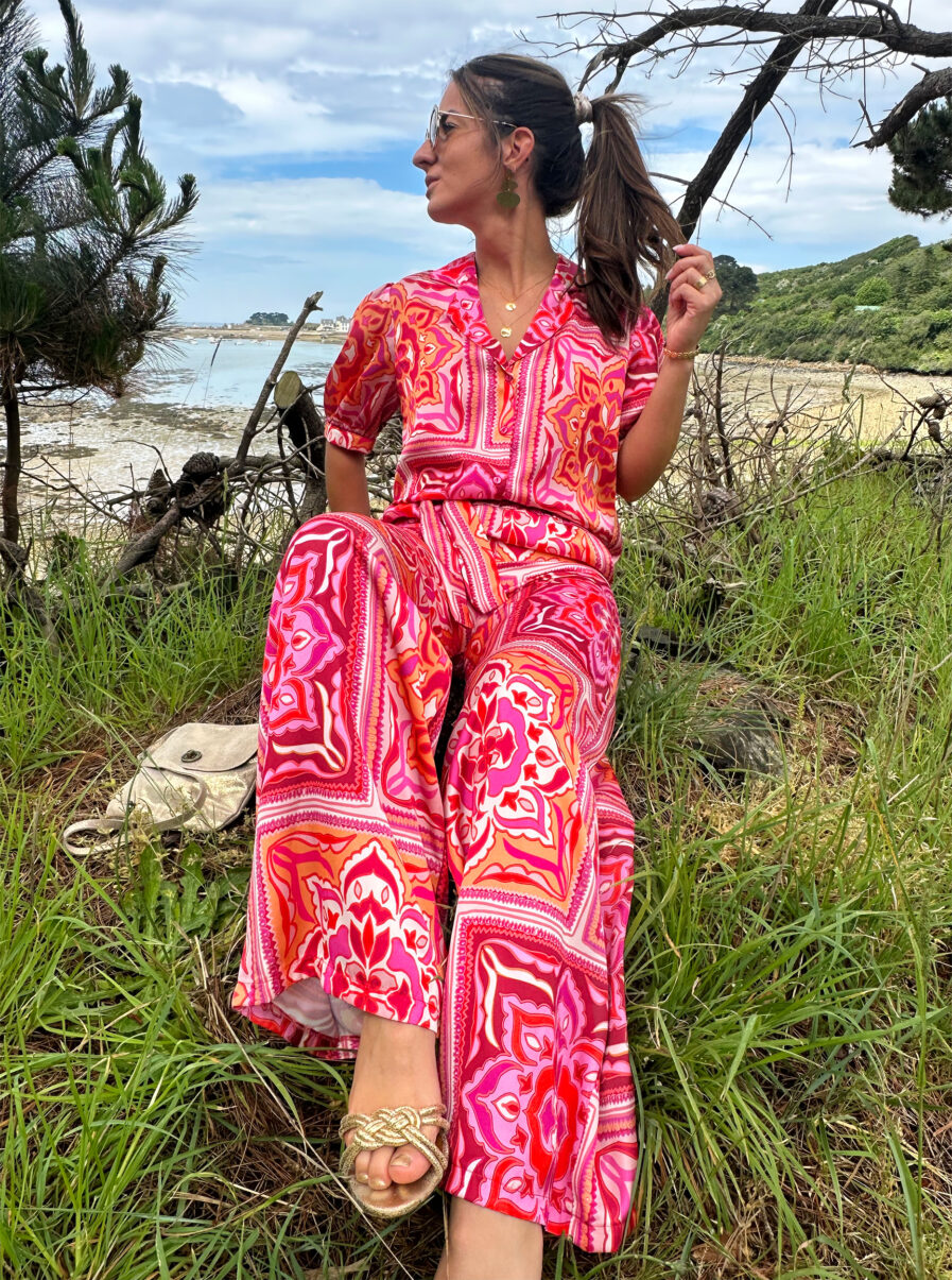 Osez la couleur avec notre nouveau pantalon Pepa qui ajoutera du pep’s à tous vos looks ! Pantalon fluide tissu satiné Imprimé baroque fuchsia, rose et orange 2 poches côtés Ceinture à la taille Taille élastiquée pour un maximum de confort Fabrication Française Création LES PIPLETTES