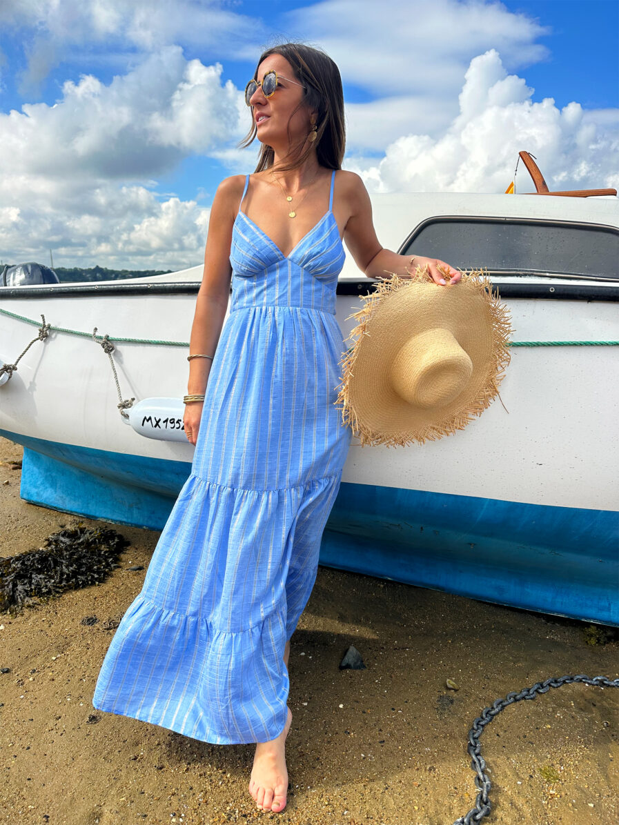 DANIELA est notre sublime robe dos nu au style bohême chic ! Son joli coloris bleu ciel et ses rayures dorées en lurex vous sublimeront. Son dos nu et son noeud délicat ajoutent une touche de sensualité à ce modèle tellement féminin. Associez-la à des sandales naturelles ou dorées et des bijoux dorés pour un look irrésistible. Taille élastiquée pour un maximum de confort Fines bretelles réglables Empiècement sous poitrine pour une silhouette flatteuse Modèle doublé