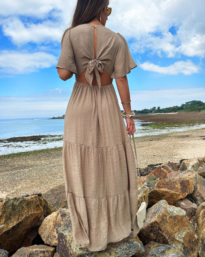 Laissez apparaître votre joli bronzage avec la robe Sara et son superbe dos nu ! Robe longue fluide Décolleté en V Empiècement sous poitrine Dos partiellement nu fermé par un joli noeud Taille élastiquée pour un maximum de confort Modèle doublé