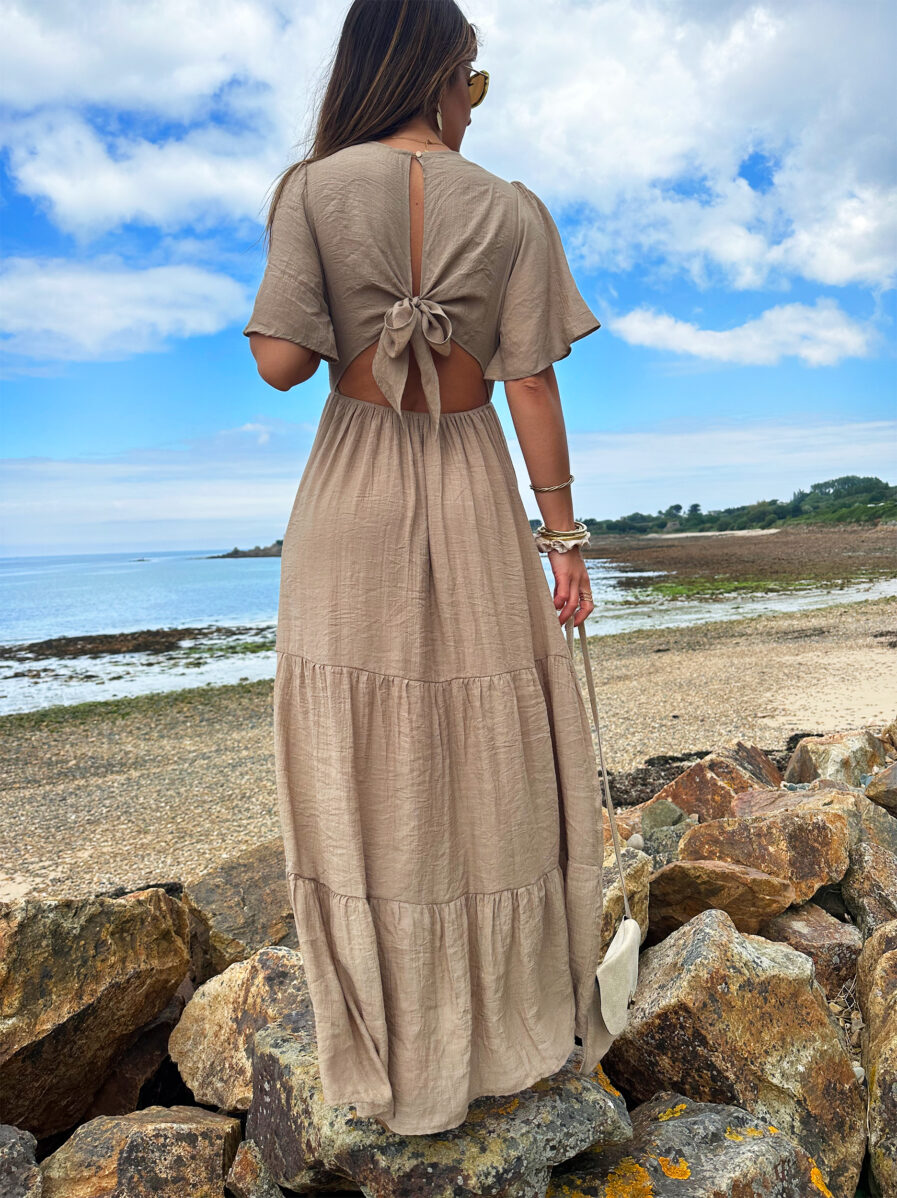 Laissez apparaître votre joli bronzage avec la robe Sara et son superbe dos nu ! Robe longue fluide Décolleté en V Empiècement sous poitrine Dos partiellement nu fermé par un joli noeud Taille élastiquée pour un maximum de confort Modèle doublé