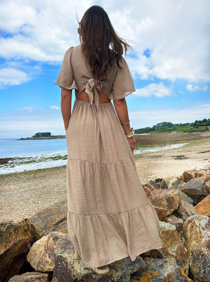 Laissez apparaître votre joli bronzage avec la robe Sara et son superbe dos nu ! Robe longue fluide Décolleté en V Empiècement sous poitrine Dos partiellement nu fermé par un joli noeud Taille élastiquée pour un maximum de confort Modèle doublé