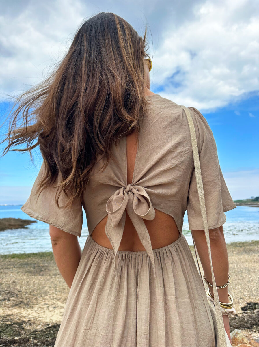 Laissez apparaître votre joli bronzage avec la robe Sara et son superbe dos nu ! Robe longue fluide Décolleté en V Empiècement sous poitrine Dos partiellement nu fermé par un joli noeud Taille élastiquée pour un maximum de confort Modèle doublé