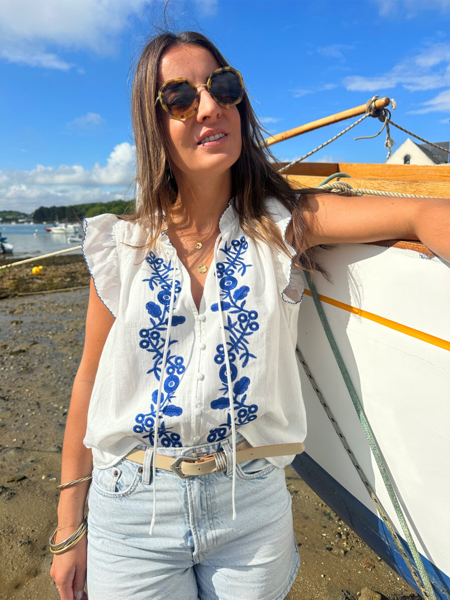 Le Top Valentina représente l’élégance et la féminité grâce à ses somptueux détails en broderie bleue. Ses détails apporteront une touche de romantisme à vos looks. Idéale à porter avec un jean ou un short taille haute. Joli décolleté V Volants à l’encolure et aux manches Modèle boutonné sur l’avant 2 liens Détail de broderies bleues sur l’avant
