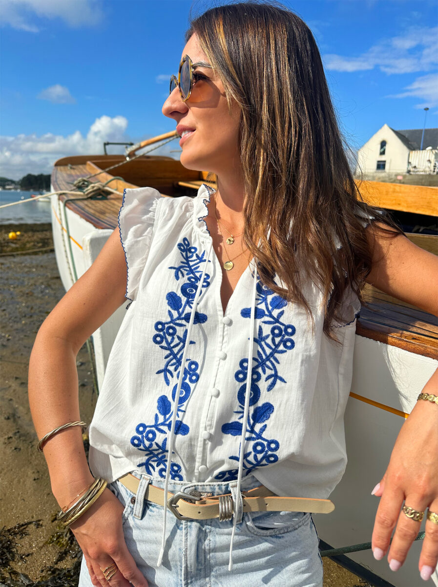 Le Top Valentina représente l’élégance et la féminité grâce à ses somptueux détails en broderie bleue. Ses détails apporteront une touche de romantisme à vos looks. Idéale à porter avec un jean ou un short taille haute. Joli décolleté V Volants à l’encolure et aux manches Modèle boutonné sur l’avant 2 liens Détail de broderies bleues sur l’avant