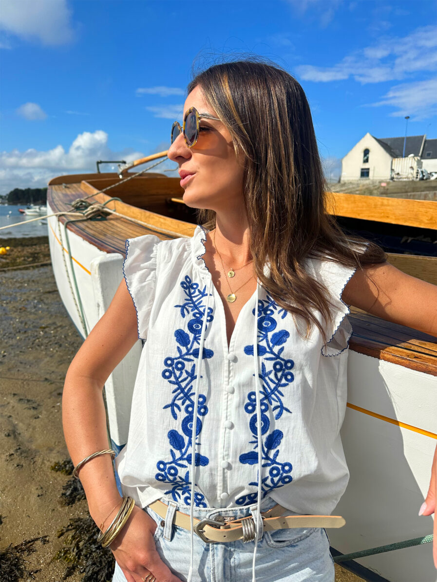 Le Top Valentina représente l’élégance et la féminité grâce à ses somptueux détails en broderie bleue. Ses détails apporteront une touche de romantisme à vos looks. Idéale à porter avec un jean ou un short taille haute. Joli décolleté V Volants à l’encolure et aux manches Modèle boutonné sur l’avant 2 liens Détail de broderies bleues sur l’avant