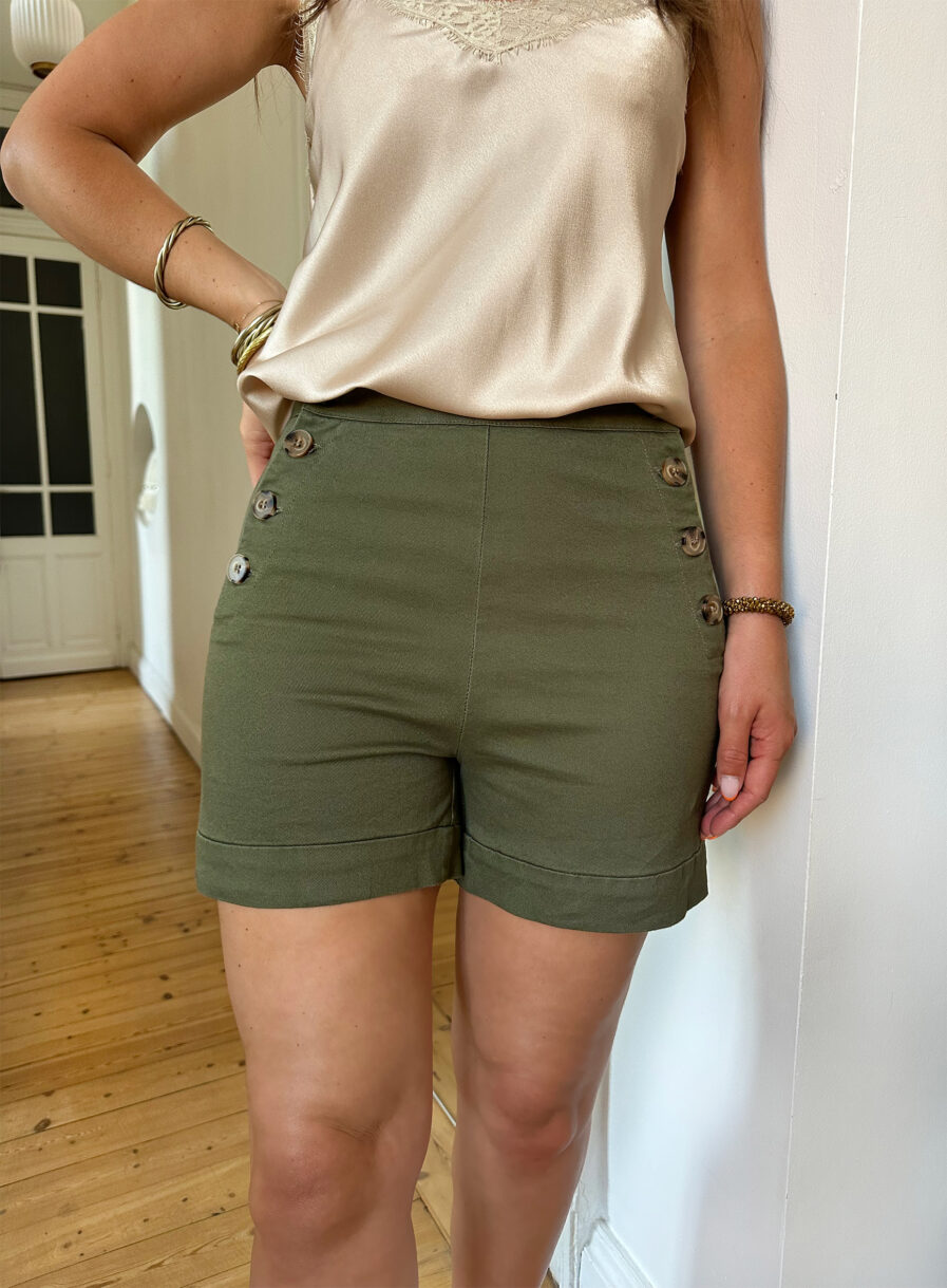 Voici TOM, notre nouveau short en coton taille haute ! On craque pour son coloris kaki, intemporel et tendance. Avec sa taille haute, et ses jolis boutons côtés, il mettra votre taille en valeur. Le mélange coton et élasthanne assure un confort optimal. On aime le porter avec un joli haut ecru et une paire de sandales !