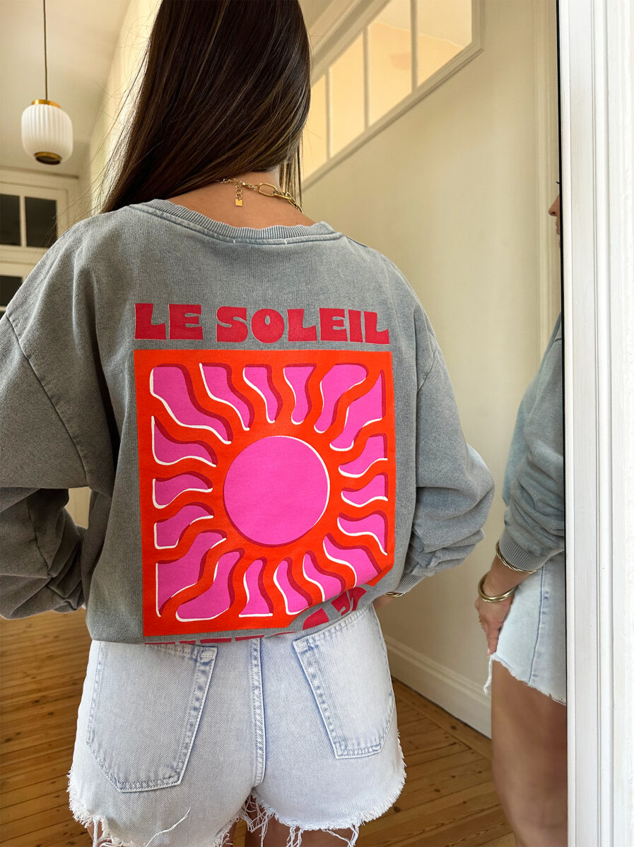 Adoptez un look ensoleillé avec nos sweats Le Soleil ajoutant une touche estivale et positive à votre tenue ! Ce sweat gris 100% coton mise sur le confort sans faire l’impasse sur le style. – Son col rond et sa coupe avec le bout des manches et le bas du sweat élastiqué en font une pièce facile à porter au quotidien. – Ce qui le rend unique ? Un logo coloré sérigraphié sur le devant, représentant un soleil accompagné de l’inscription « Le Soleil » dans des teintes chaudes de rose et d’orange. – À l’arrière, ce même motif est repris en version agrandie, avec l’inscription Le soleil. – Une pièce pleine de bonne humeur, parfaite pour faire rayonner vos looks, même les jours plus frais.