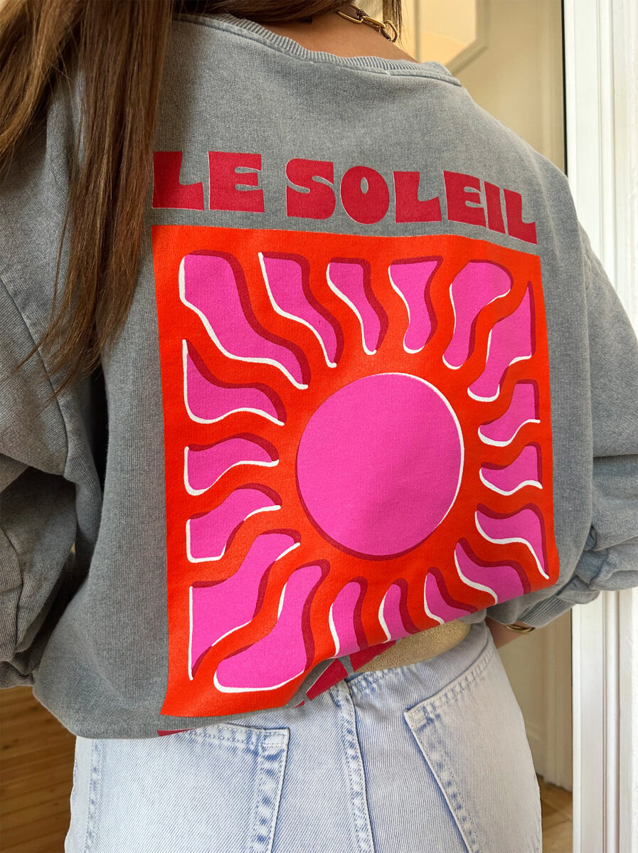 Adoptez un look ensoleillé avec nos sweats Le Soleil ajoutant une touche estivale et positive à votre tenue ! Ce sweat gris 100% coton mise sur le confort sans faire l’impasse sur le style. – Son col rond et sa coupe avec le bout des manches et le bas du sweat élastiqué en font une pièce facile à porter au quotidien. – Ce qui le rend unique ? Un logo coloré sérigraphié sur le devant, représentant un soleil accompagné de l’inscription « Le Soleil » dans des teintes chaudes de rose et d’orange. – À l’arrière, ce même motif est repris en version agrandie, avec l’inscription Le soleil. – Une pièce pleine de bonne humeur, parfaite pour faire rayonner vos looks, même les jours plus frais.