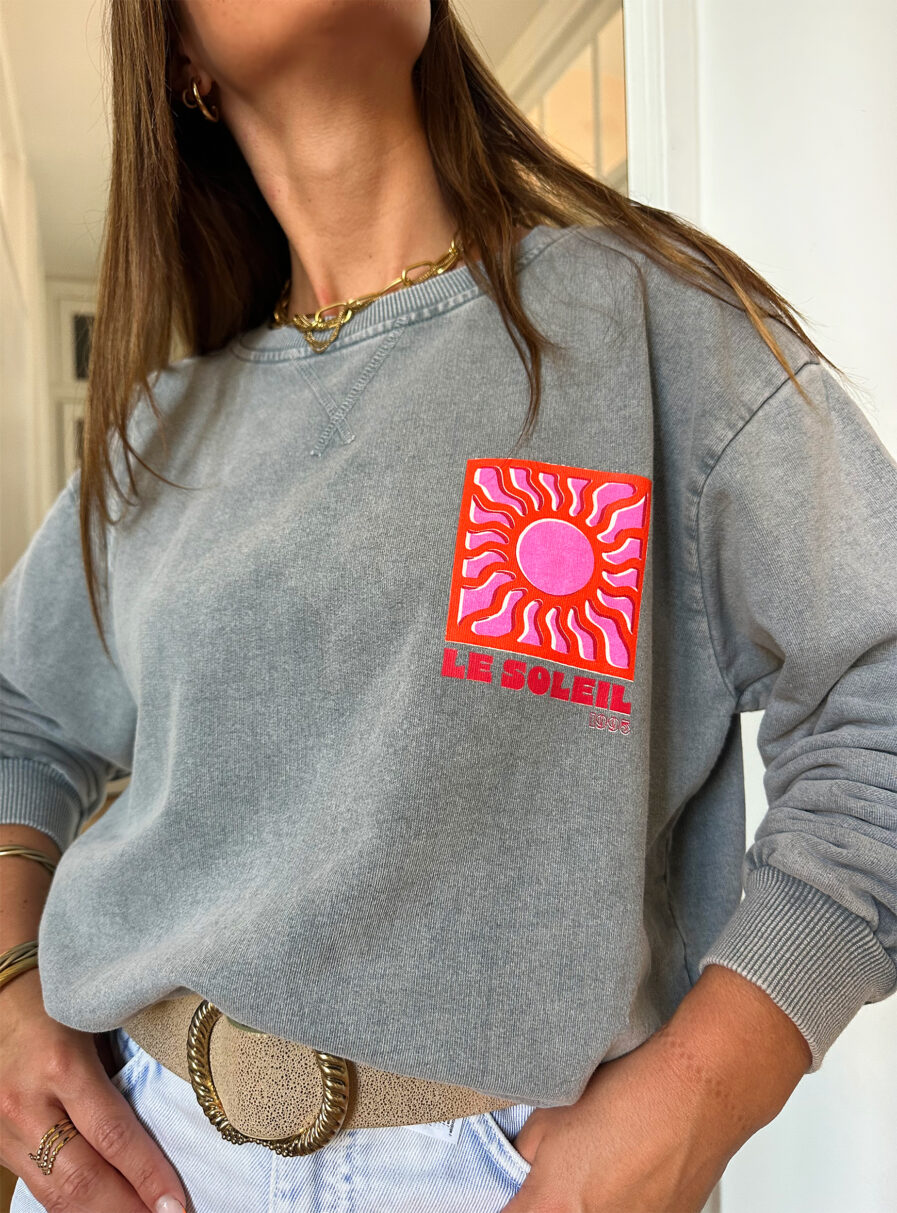 Adoptez un look ensoleillé avec nos sweats Le Soleil ajoutant une touche estivale et positive à votre tenue ! Ce sweat gris 100% coton mise sur le confort sans faire l’impasse sur le style. – Son col rond et sa coupe avec le bout des manches et le bas du sweat élastiqué en font une pièce facile à porter au quotidien. – Ce qui le rend unique ? Un logo coloré sérigraphié sur le devant, représentant un soleil accompagné de l’inscription « Le Soleil » dans des teintes chaudes de rose et d’orange. – À l’arrière, ce même motif est repris en version agrandie, avec l’inscription Le soleil. – Une pièce pleine de bonne humeur, parfaite pour faire rayonner vos looks, même les jours plus frais.