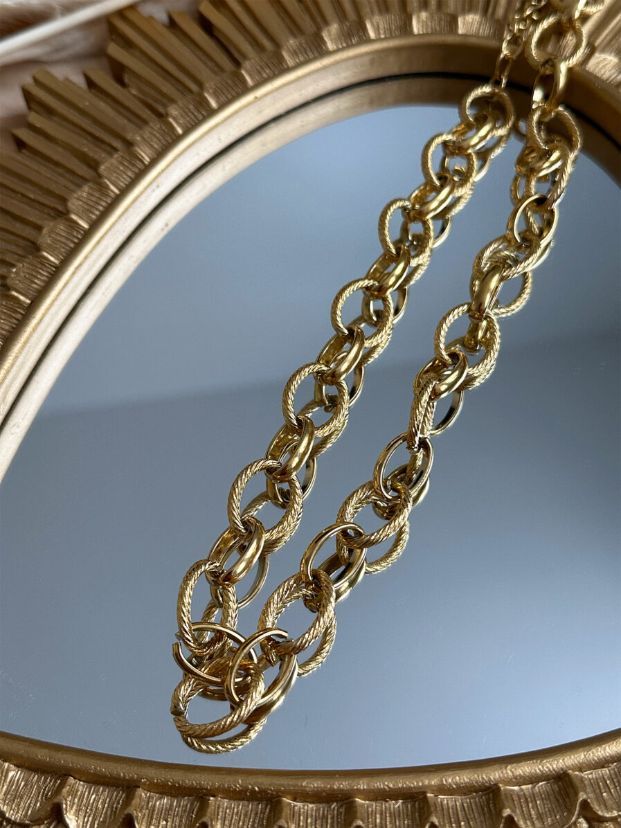 Le collier Carméla est le bijou intemporel qui traverse les saisons sans jamais perdre de son éclat. Ses maillons dorés texturés en acier inoxydable lui donnent une allure à la fois moderne et classique, idéale pour toutes celles qui aiment les pièces fortes et élégantes. Grâce à son design chic et minimaliste, Carméla se porte avec absolument tout ! Matière : acier inoxydable Longueur : 20 cm Fermoir toggle pratique et stylé