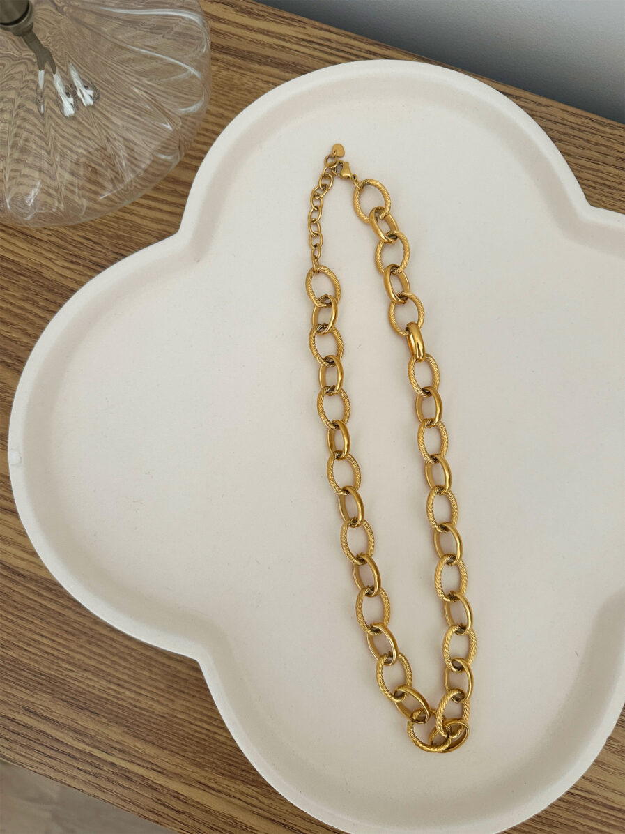 Le collier Carméla est le bijou intemporel qui traverse les saisons sans jamais perdre de son éclat. Ses maillons dorés texturés en acier inoxydable lui donnent une allure à la fois moderne et classique, idéale pour toutes celles qui aiment les pièces fortes et élégantes. Grâce à son design chic et minimaliste, Carméla se porte avec absolument tout ! Matière : acier inoxydable Longueur : 20 cm Fermoir toggle pratique et stylé