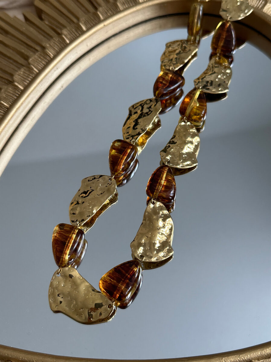Sublimez vos tenues avec l’élégance singulière collier Zélie. Composé de maillons irréguliers dorés martelés et de perles aux reflets ambrés, il apporte une touche sophistiquées et audacieuse à vos looks. Matière : acier inoxydable & perles effet ambré Fermoir : mousqueton classique Longueur : 18cm ajustable
