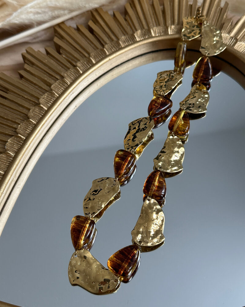 Sublimez vos tenues avec l’élégance singulière collier Zélie. Composé de maillons irréguliers dorés martelés et de perles aux reflets ambrés, il apporte une touche sophistiquées et audacieuse à vos looks. Matière : acier inoxydable & perles effet ambré Fermoir : mousqueton classique Longueur : 18cm ajustable