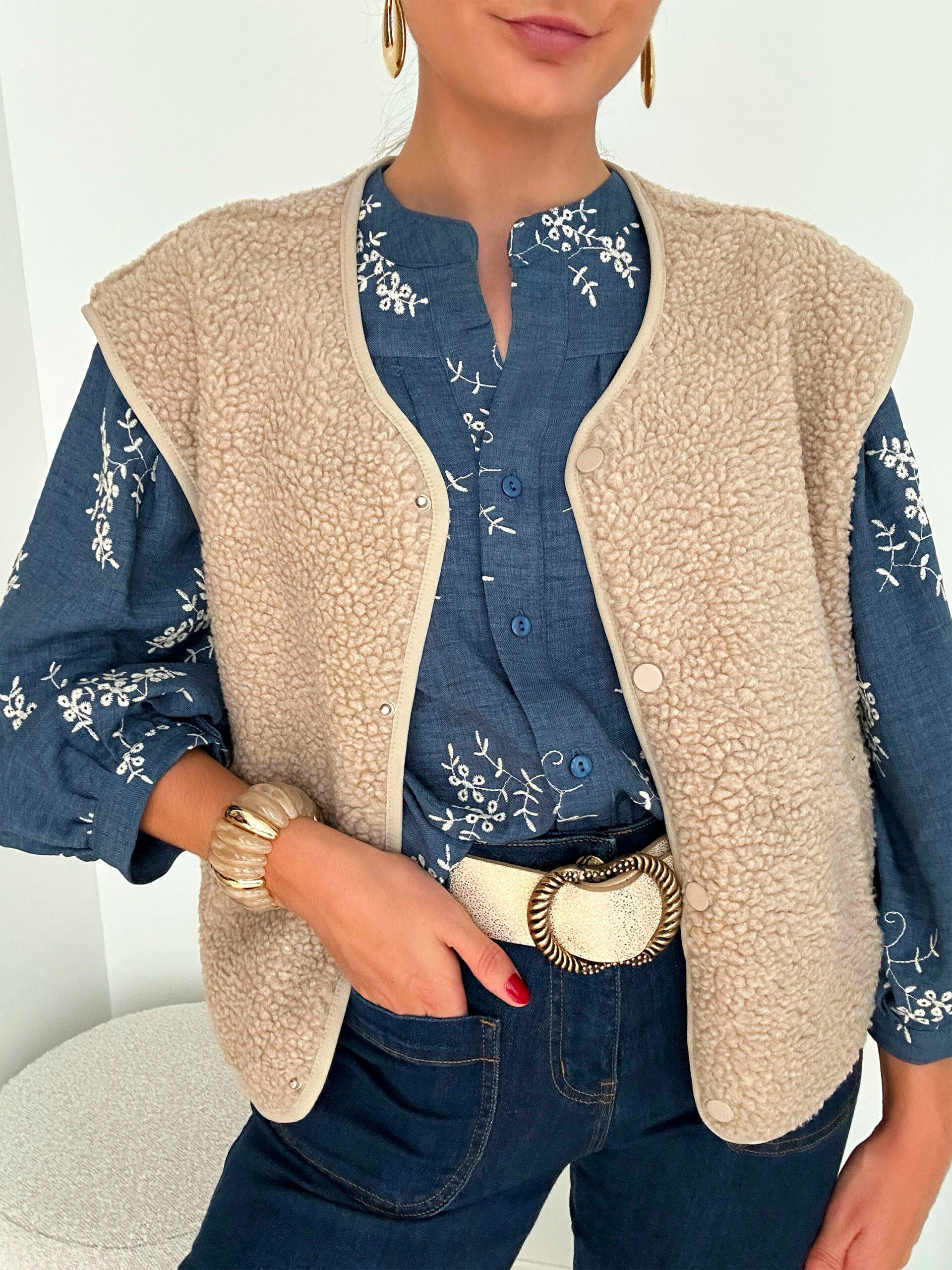 gilet-mila-lespiplettes1 Affrontez l’hiver avec élégance et chaleur grâce à notre gilet MILA sans manches taupe l ! Une pièce incontournable pour un style chic et confortable par temps froid. Coupe droite légèrement oversize Ouverture boutonnée devant 2 poches côtés Gilet effet moumoute taupe